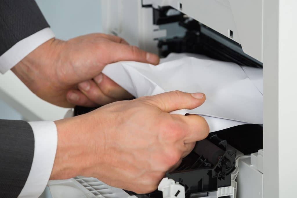 Ziehen Sie das eingeklemmte Papier vorsichtig mit beiden Händen aus dem Drucker