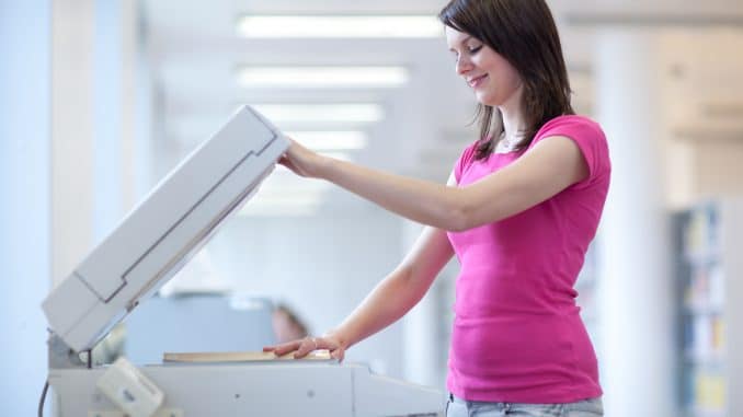 pretty young woman using a copy machine (shallow DOF; color tone